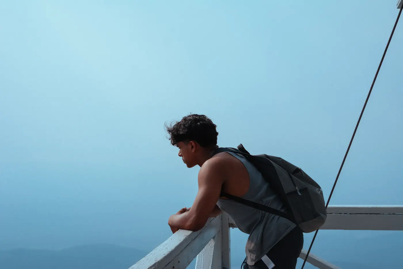 A traveler leaning over the rail of a boat