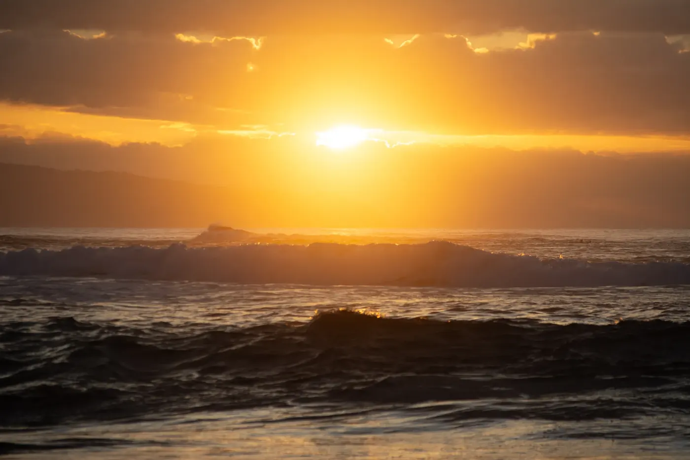Sun setting over dark ocean waves