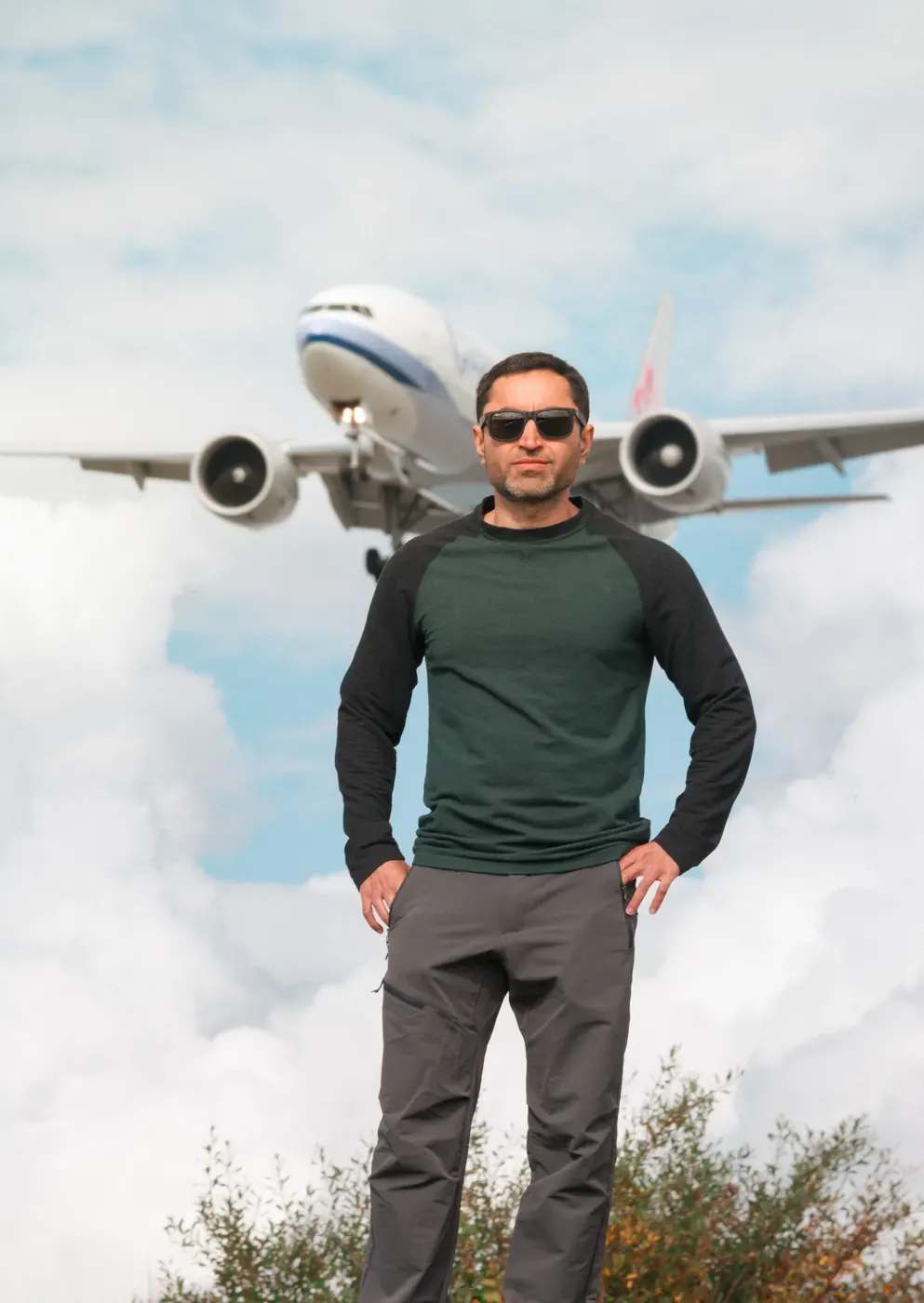 A man standing beneath the approach of a passenger aircraft