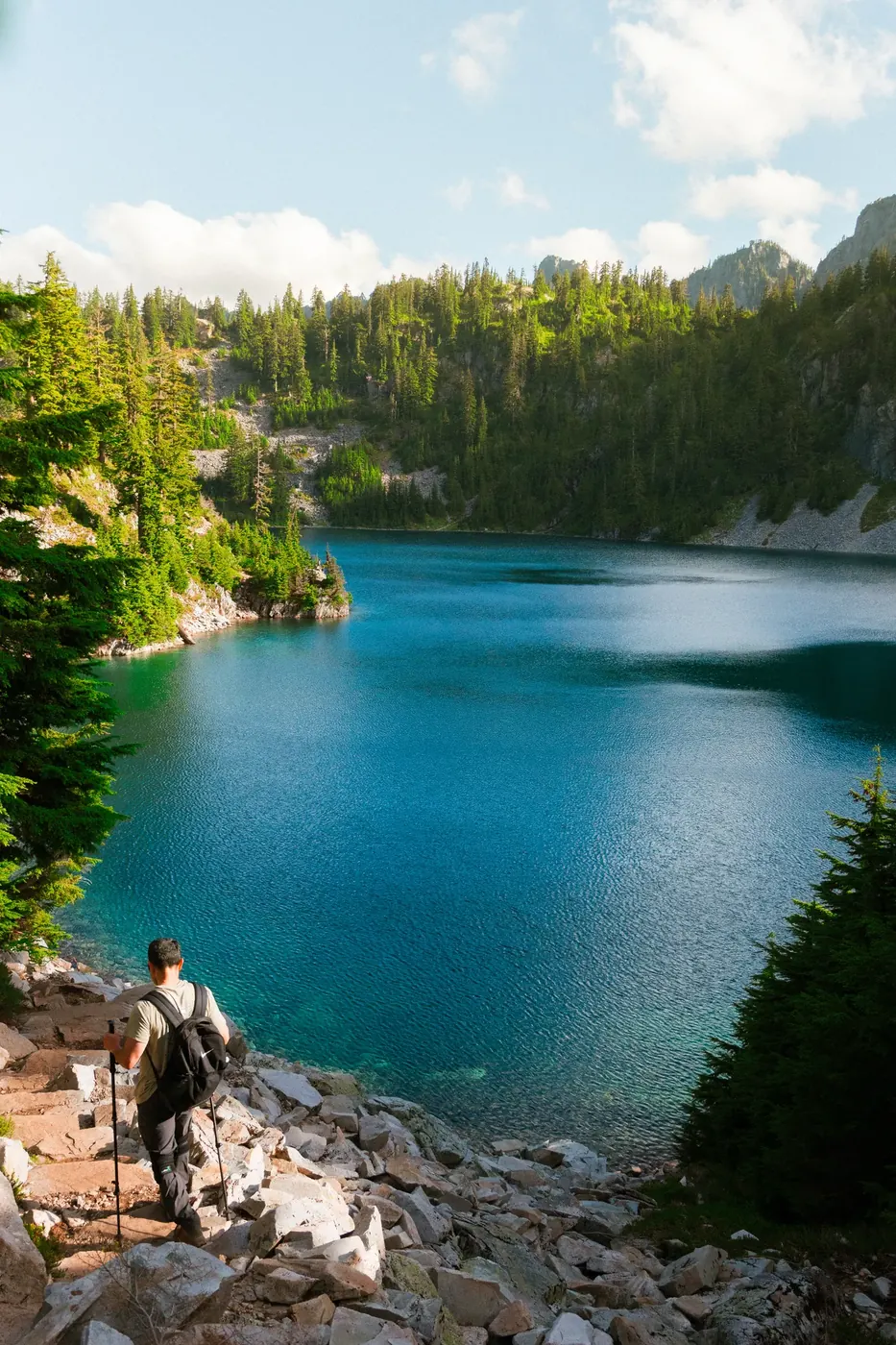 A deep blue alpine lake beneath dense evergreen forest
