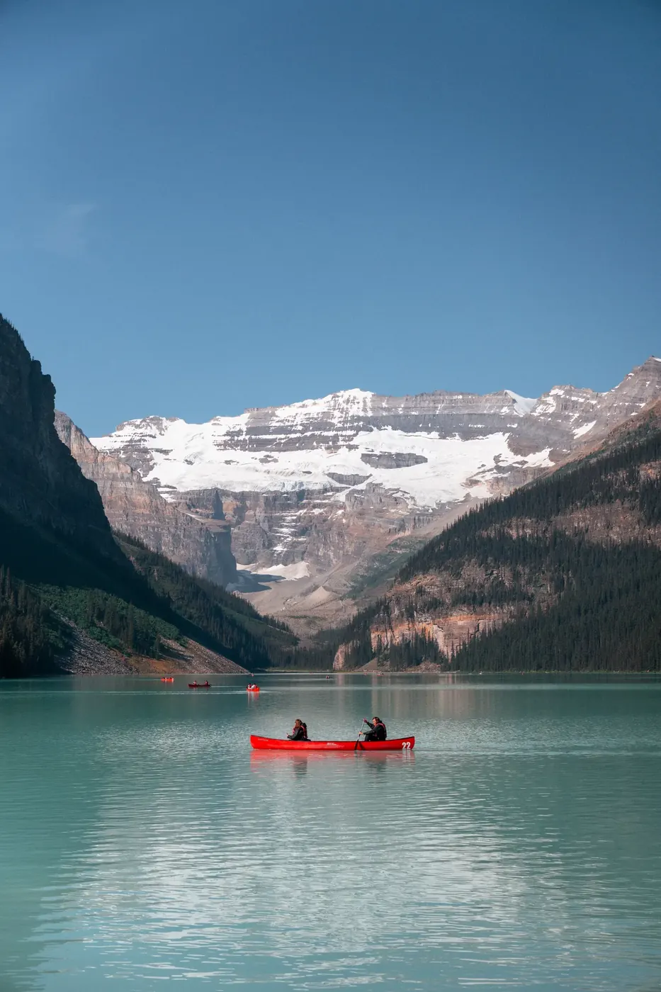 A pale mountain lake beneath a broad glacier