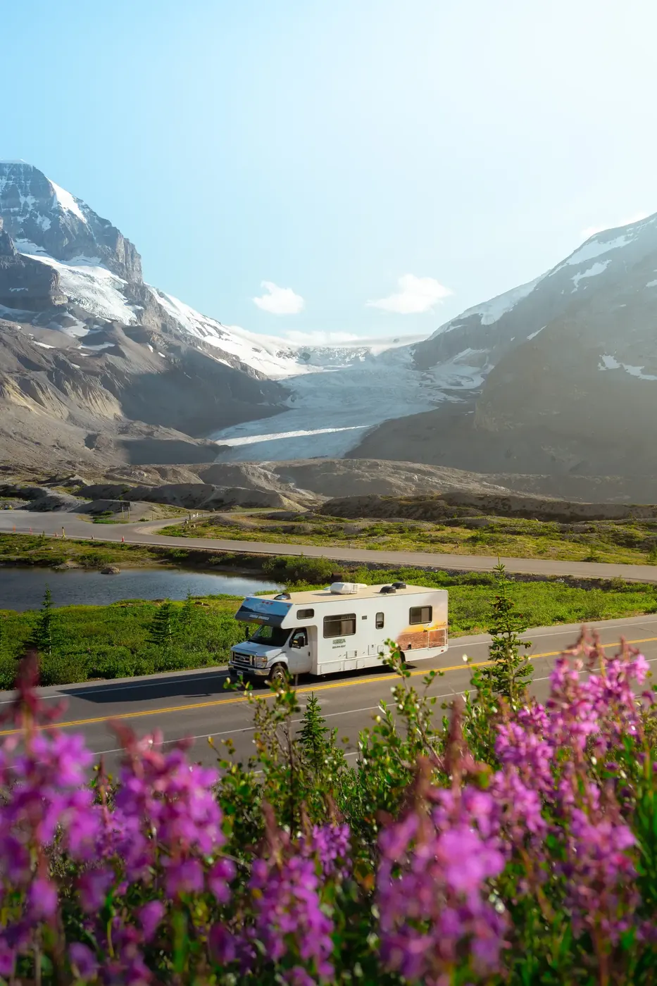 A camper van parked beneath a glacier