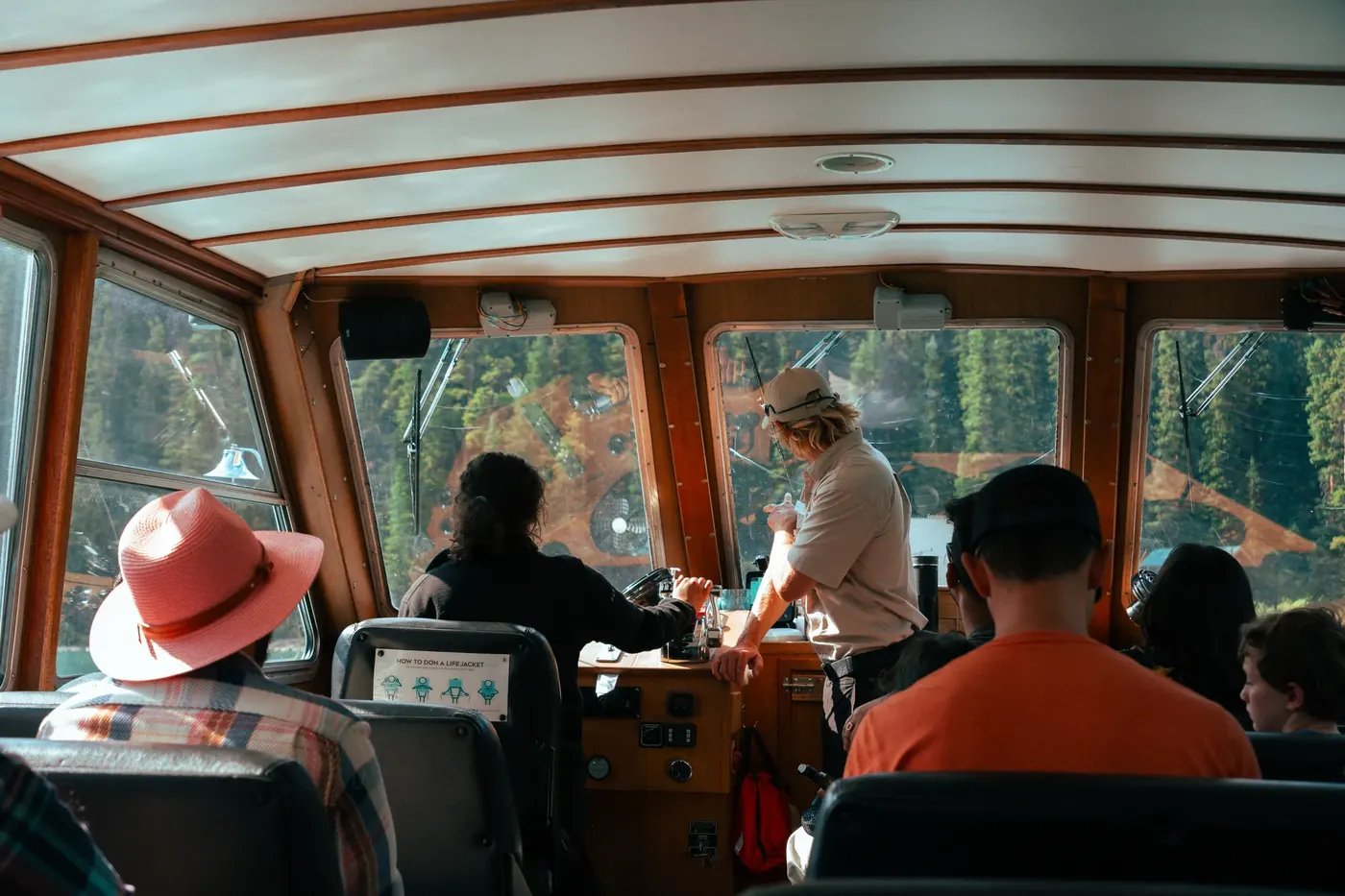 Travelers looking through the windows of a wooden tour boat