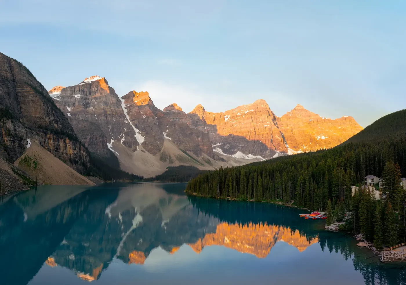 Golden mountain peaks reflected in a calm turquoise lake
