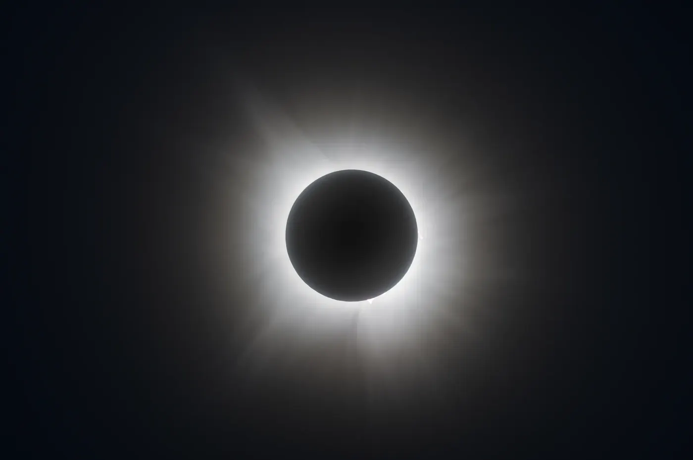 The solar corona glowing around the moon during a total eclipse